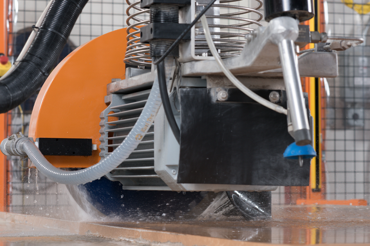 BACA's Robo Sawjet 2.0 in the process of cutting a stone slab. The image shows its blade and waterjet in use.