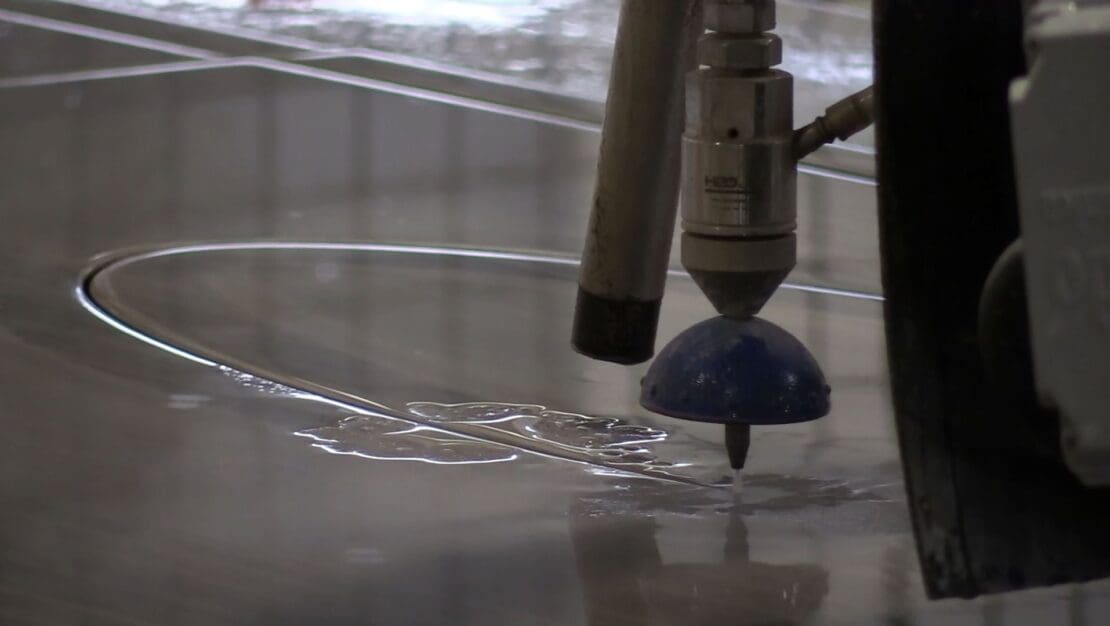 The Robo SawJet's waterjet capability cutting an arc into stone